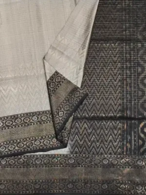 Close-up of metallic silver-grey Soft Silk Saree with Ikat waves and bronze-gold zari border